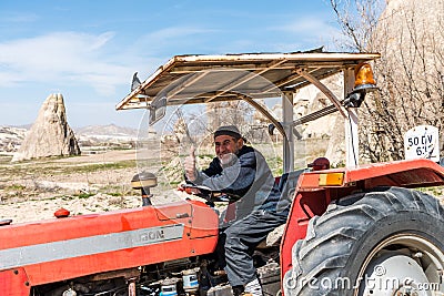 An old male Turkish farmer driving a tractor in the town of Goreme, Cappadocia, a historical region of Turkey Editorial Stock Photo