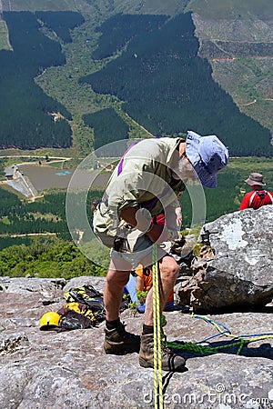 Old man adjust gear for rope climbing Stock Photo