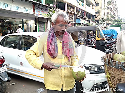 Old man cutting coconut with knife Editorial Stock Photo