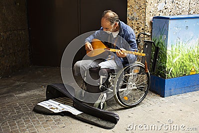 Old man disabled playing Pin Harp music for show German people and foreign travelers on street market in Ostenhellweg road at Editorial Stock Photo