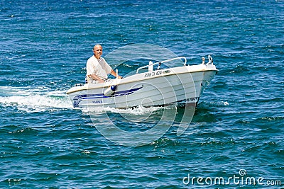 Old man driving motorboat Editorial Stock Photo