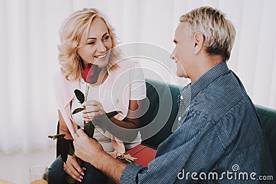 Old Man Giving Rose to Woman in Waiting Room. Stock Photo