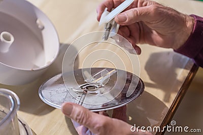 Old man grandpa with hands builds assembled disassembles a kitchen mashine into the parts, Germany Stock Photo