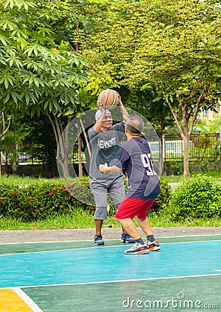 Old man happy with exercise to play basketball at BangYai Park. Editorial Stock Photo