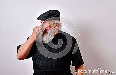 Old man holds nose from bad smell Stock Photo