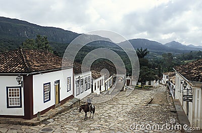 Old man on a horse along an unspoiled colonial street in Tiradentes, Brazil. Editorial Stock Photo