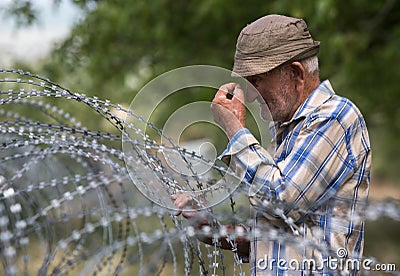 Old man on local stand near barbed wire Editorial Stock Photo