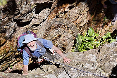 Old man looks up while climbing Stock Photo