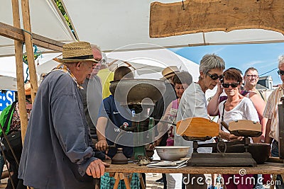 An old man operates an ancient machine to grind grain Editorial Stock Photo