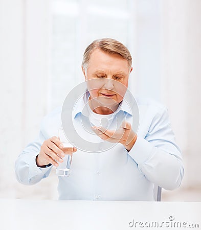Old man with pills ang glass of water Stock Photo