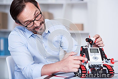 Old man playing with a robot having fun Stock Photo