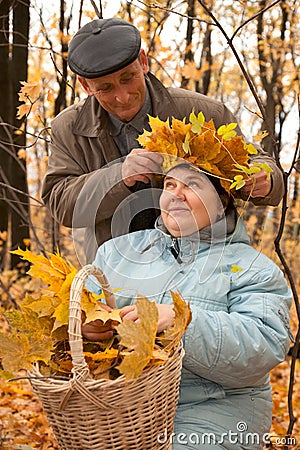 Old man put on his wife wreath of maple leaves Stock Photo