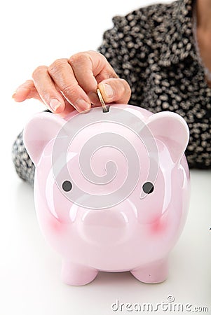Old man puts euro coins into piggy bank in hand Stock Photo