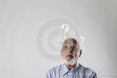 Old man and question marks. Dementia and ignorance. Confused old man Stock Photo