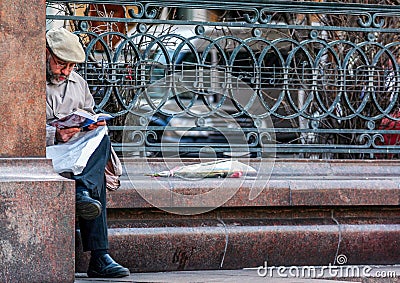An old man reading news paper by the monument to Peter Tchaikovsky. Tourists walking around Moscow. Editorial Stock Photo