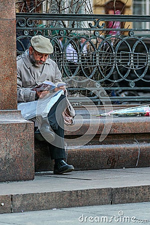 An old man reading news paper by the monument to Peter Tchaikovsky. Tourists walking around Moscow. Editorial Stock Photo