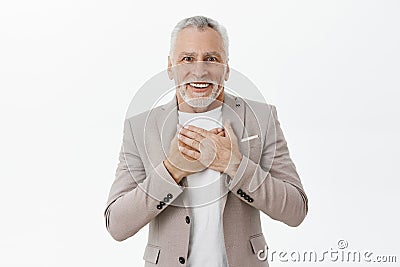 Old man receiving heartwarming and touching gift pleased and delighted smiling with crooked teeth at camera holding Stock Photo