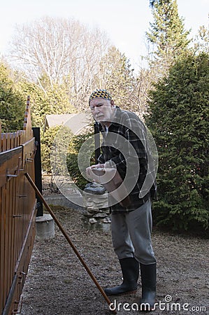 Old man repairing a gate Stock Photo