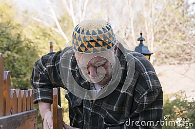 Old man repairing a gate Stock Photo