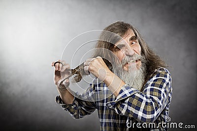 Old Man Scissors Cutting Hair, Senior with Crazy Face Self Trim Stock Photo