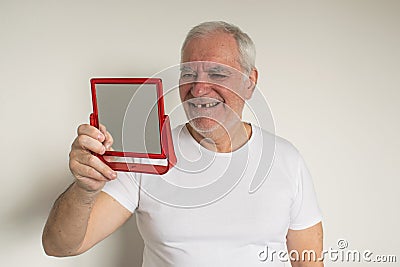 Old man senior face closeup missing tooth smile proper tooth care white t shirt visit dentist Stock Photo