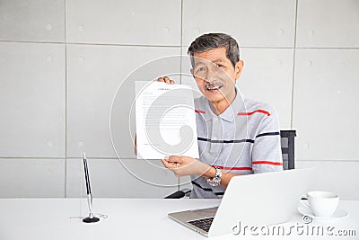 Old man show contract document after sign and smile with happy feeling Stock Photo