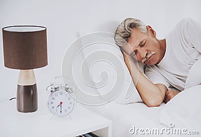 Old Man Sleeping in Comfortable White Bed at Home. Stock Photo