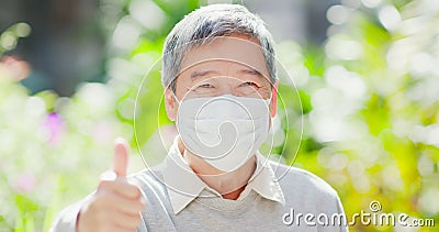 Old man thumbup with mask Stock Photo