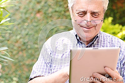 Old man using digital tablet. Stock Photo