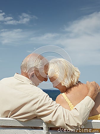 Old man and woman on bench at the sea Stock Photo