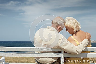 Old man and woman on bench at the sea Stock Photo