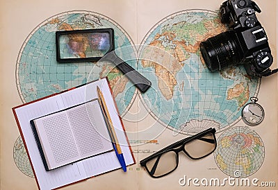 Old map of the hemispheres on it a camera, clock, magnifier and a notebook Stock Photo