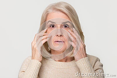 Old mature woman looking at camera worried about face wrinkles Stock Photo