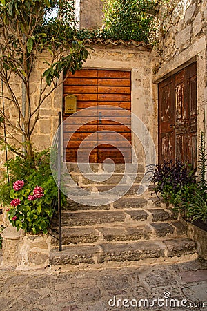Old medieval city. Ancient European courtyard, stone stairs and old wooden gates doors to a residential building Stock Photo