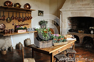 Old medieval kitchen copper pans fireplace table chairs Stock Photo