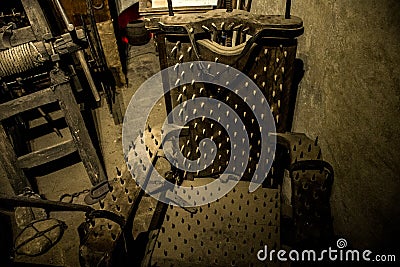 Old medieval torture chamber with chair and tools Stock Photo