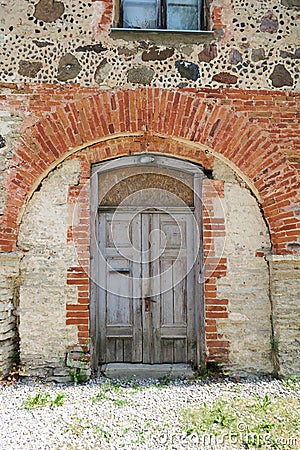 Old medieval wooden door in a stone wall Stock Photo