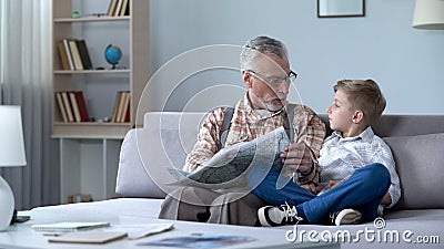 Old man veteran viewing map with grandson showing front line, remembering war Stock Photo