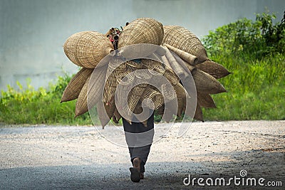 Old men are walking for selling wicker craftsman making traditional bamboo fish trap or weave in Hanoi, Vietnam Stock Photo