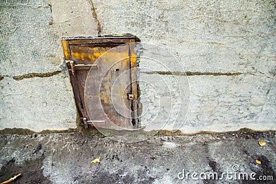 Old metal door in a concrete wall Stock Photo