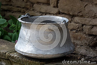 Old metal water container in the garden- traditional Bulgarian copper water container bakir. Used to bring water from the well. Stock Photo