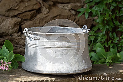 Old metal water container in the garden- traditional Bulgarian copper water container bakir. Used to bring water from the well. Stock Photo