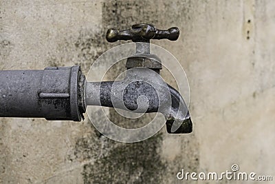Old Metal Water Spigot on Concrete Wall Stock Photo