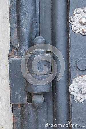 The old metal wrought-iron door is locked with a padlock. Closed metal lock. Stock Photo