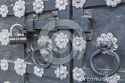 The old metal wrought-iron door is locked with a padlock. Closed metal lock. Stock Photo