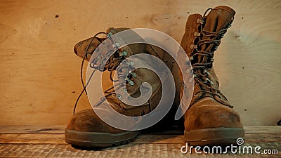 Old military boots on a wooden table. Old brown military boots on a bright wooden table made of boards Old military boots on a wooden table. Old brown military boots on a bright wooden table made of boards