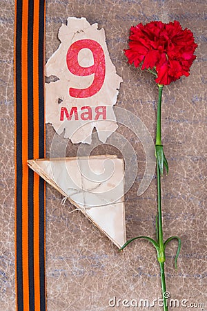 old military letters with carnations, St. George ribbon and inscription on May 9 on a scrap of leaf Stock Photo