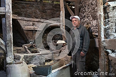 Old mill for grinding grain up close. The miller grinds grain Stock Photo