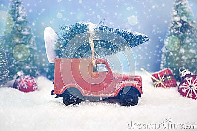 Old miniature truck or oldimer with a christmas tree on the roof driving trough a winterly landscape with some kind of christmas d Stock Photo