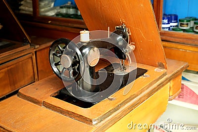 An old model of sewing machine on wood table Stock Photo